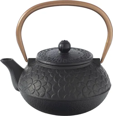 A black cast iron teapot with a copper handle and a floral embossed pattern.