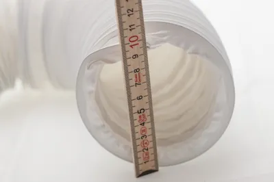 A flexible white hose with a ruler measuring its diameter.