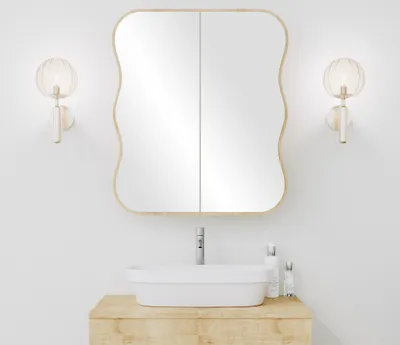 A bathroom vanity with a sink, mirror, and wall sconces.