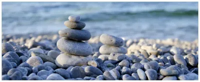 Produktbild von Wallario Premium Glasbild, freischwebende Optik, kräftige Farben, Größe 80 x 32 cm Motiv Steinstapel am Strand