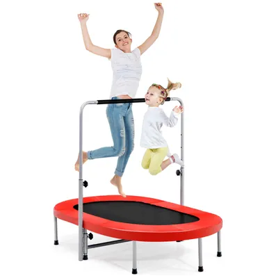 A mother and child are jumping on a red oval trampoline with a safety bar.