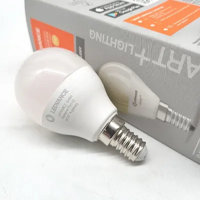 A close-up shot of a white LED light bulb and its packaging.