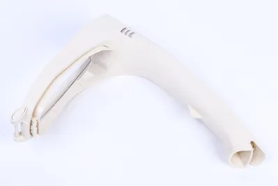 A beige plastic part, likely a component of a vacuum cleaner, is shown against a white background.