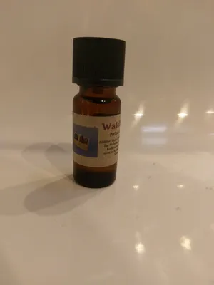 Kleine braune Flasche mit einem schwarzen Verschluss. Auf dem Etikett steht "Waldbeere".