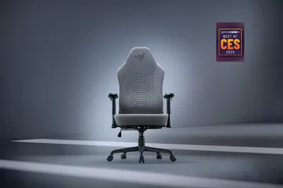 A gaming chair is shown in a studio setting with dramatic lighting.