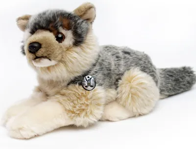 A plush toy wolf lying down on a white background.