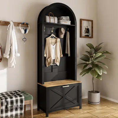 An entryway or hallway with a black arched hall tree, a bench with a green cushion and a plaid throw, and a potted plant.