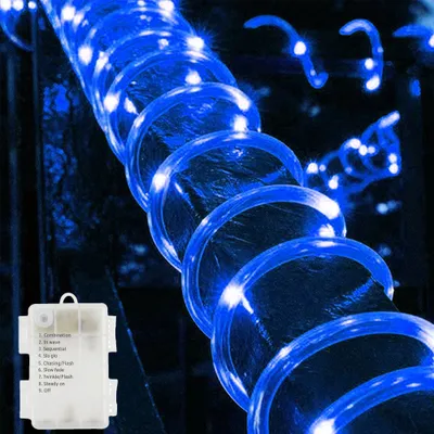 A close-up of blue LED rope lights coiled around a dark background, with a small white battery pack in the bottom left corner.