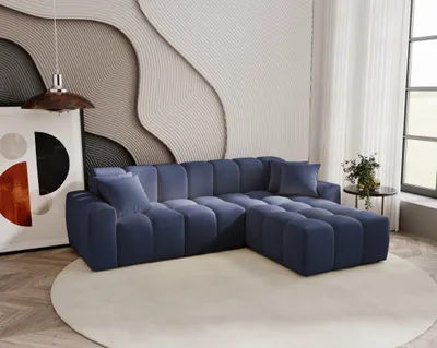 A modern living room with a blue sectional sofa, a large abstract artwork, and a decorative wall.