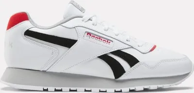 A side view of a white Reebok sneaker with black and red accents.
