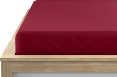 A close-up view of a burgundy fitted sheet on a wooden bed frame.