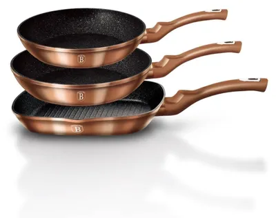 Three copper-colored frying pans stacked on top of each other.