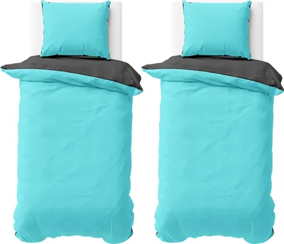Two identical sets of bedding laid out on beds.