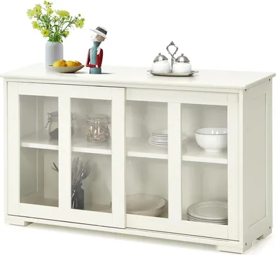 A white sideboard cabinet with glass sliding doors, displaying various kitchen items and decorative elements on top.