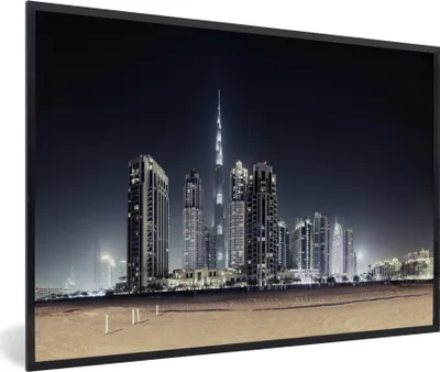 Produktbild von MuchoWow® MuchoWow® Gerahmtes Poster Der Burj Khalifa erhellt den Himmel über Dubai mit anderen Wolkenkratzern 60x40 cm - Poster mit zchwarzem Bilderrahmen - Printing - Wanddeko Schlafzimmer