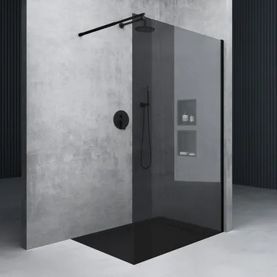 A modern walk-in shower with black glass and a concrete wall.