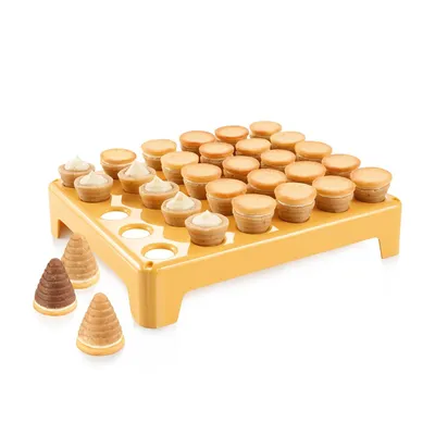 A yellow stand holding small pastry cups, with three cone-shaped pastries in the foreground.
