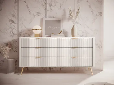 A beige dresser with gold handles is shown in a well-lit room with marble-patterned walls.