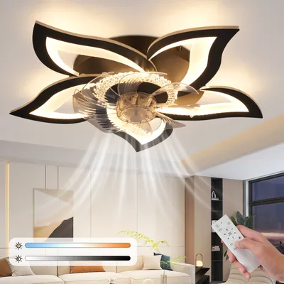 A modern ceiling fan with integrated LED lighting, shaped like a flower, is shown in a living room setting. The fan is activated, circulating air downwards, and a remote control is held in a person's hand. A color temperature slider is also visible.