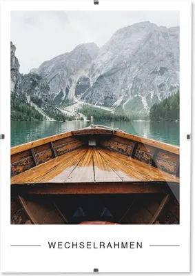 View from inside a wooden boat looking out at a lake and mountains.