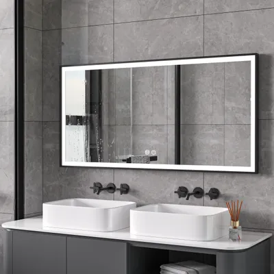 A modern bathroom vanity with two sinks and a large illuminated mirror.