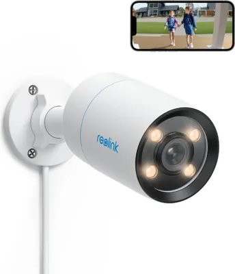A Reolink security camera is mounted on a wall, with a smartphone displaying a live feed of two children walking.