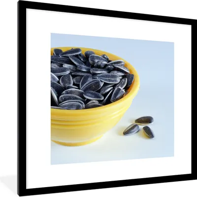 Produktbild von MuchoWow® Gerahmtes Poster Sonnenblumenkerne in einer gelben Schale mit ein paar heruntergefallenen Sonnenblumenkernen 40x40 cm - Poster mit Schwarzem Bilderrahmen Wandposter Rahmen Foto Bilder - Poster - Plakat im Rahmen