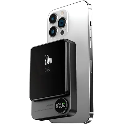 A black magnetic power bank is attached to the back of a silver smartphone.