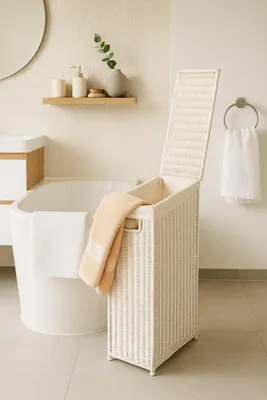 A bathroom scene with a bathtub, laundry basket, and towels.