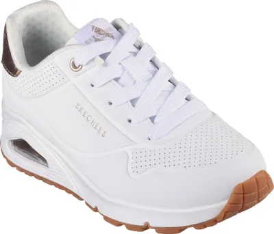 A white Skechers sneaker with gold accents and a brown sole, shown from a side-angle.