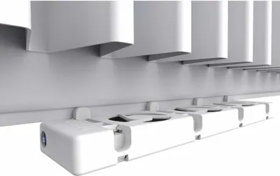 A close-up, low-angle shot of a white radiator amplifier attached to the bottom of a radiator.