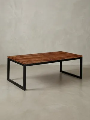 Freigestellter Couchtisch im Industrial Design mit Tischplatte aus massivem Sheesham-Holz und schwarzen Metallbeinen, Frontalansicht._#sku_BARWL6.151#