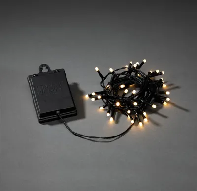 Produktbild von Konstsmide LED Lichterkette, mit an/aus Schalter und 6h Timer, mit 8 Funktionen und Memoryfunktion, gefrostet, 40 warm weiße Dioden, batteriebetrieben, Außen (IP44), schwarzes Kabel, Batterie: 4 x AA 1,5V (exkl.) - 3724-130