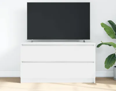 A white dresser with a television on top, placed against a white wall.