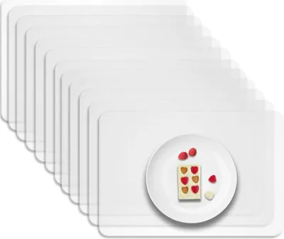 A stack of clear placemats with a white plate and a small dessert on it.