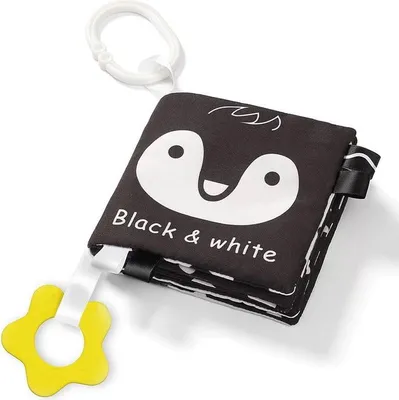A black and white fabric book for babies with a penguin design and a yellow teething ring.