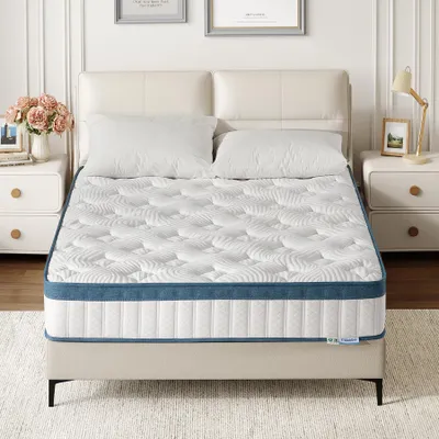 A mattress is displayed on a bed frame, with pillows and a headboard.