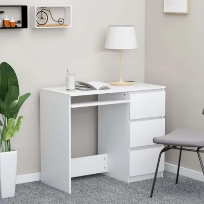 A white desk in a room setting, with a plant and shelves in the background.