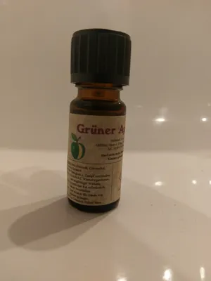 Kleine braune Flasche mit einem schwarzen Verschluss. Auf dem Etikett steht "Grüner Apfel".