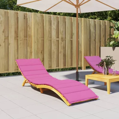 A patio scene with two pink lounge chair cushions, a wooden fence, and an umbrella.