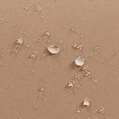 Water droplets on a textured brown fabric.