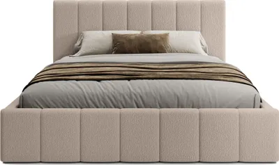 A beige upholstered bed with pillows and a throw blanket.