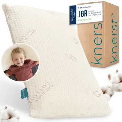 A pillow for children, with a child sleeping on it, and packaging in the background.