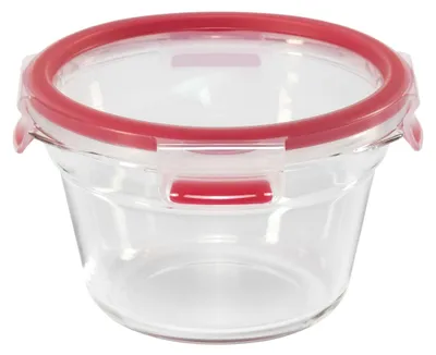 A clear, studio shot of a round glass food storage container with a red lid and locking mechanism.
