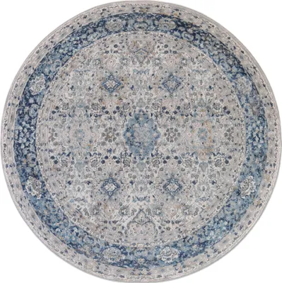A round rug with a vintage-inspired pattern in gray and blue tones.