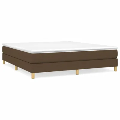 A studio shot of a boxspring bed frame with a mattress on top, against a white background.