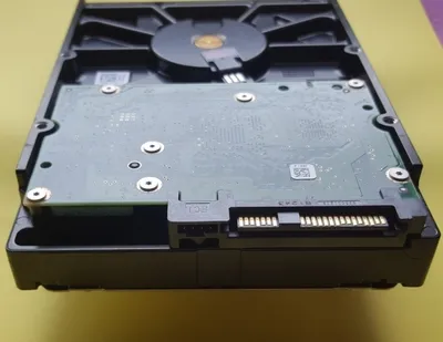 The image shows the underside of a hard drive, focusing on the circuit board and connectors.
