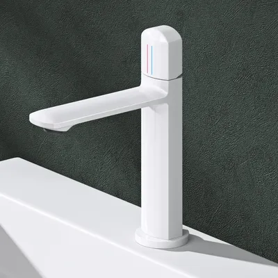A white bathroom faucet is shown on a white sink against a dark textured wall.