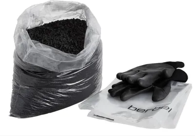 A bag of black granules and a pair of black gloves are shown on a white background.