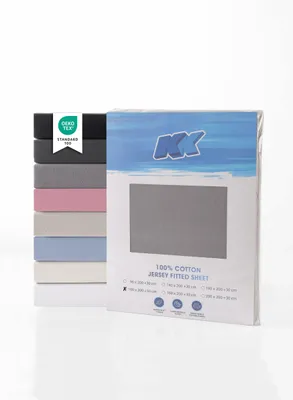 A stack of folded fitted sheets in various colors next to a packaged fitted sheet.